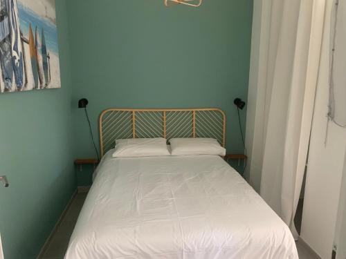 a small bed in a room with a white bedspread at Superbe appartement avec Terrasse et Vue in Bouzigues