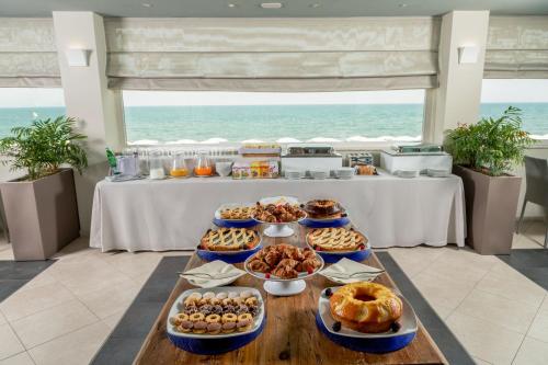 a table with many different types of food on it at Hotel Miramare in Latina