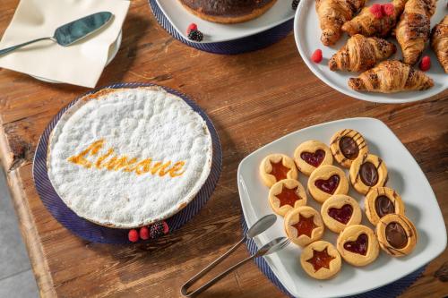 a table topped with plates of pies and pastries at Hotel Miramare in Latina