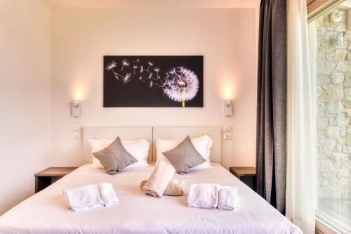 a bedroom with a white bed with two pillows at Villa Brusadela Suites Garda in Garda