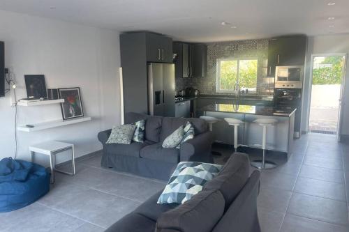 a living room with a couch and a kitchen at Spacious Villa. Large Rooftop. 4 Bedroom Sleeps 8 in Alvor