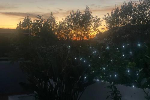 a sunset over a garden with trees in the background at Spacious Villa. Large Rooftop. 4 Bedroom Sleeps 8 in Alvor