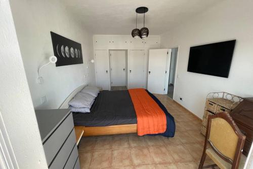 a bedroom with a bed with an orange and black blanket at Spacious Villa. Large Rooftop. 4 Bedroom Sleeps 8 in Alvor