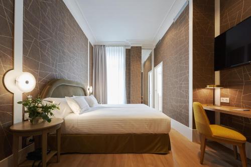a hotel room with a bed and a table and a chair at Intelier Villa Katalina in Donostia-San Sebastián