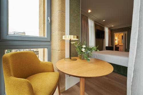 um quarto com uma cadeira, uma mesa e uma cama em Intelier Villa Katalina em San Sebastián