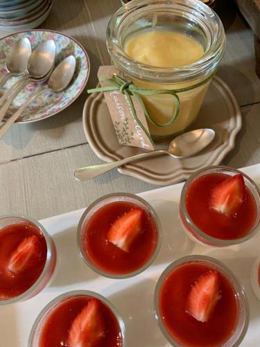 a plate of food with strawberries in small bowls at Manoir de Malagorse in Cuzance