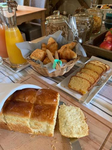 a table with bread and pastries and a basket of bread at Manoir de Malagorse in Cuzance