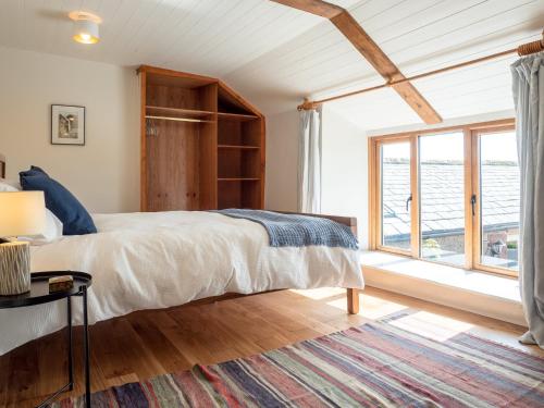a bedroom with a bed and a large window at Wayside Cottage 1637 in Millom