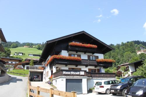 a white building with red flowers on it at Haus Straif in Brixen im Thale