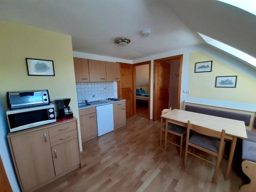 a small kitchen with a table and a microwave at Schilcherweinbau Vollmaier vlg. Wieser in Sankt Stefan ob Stainz