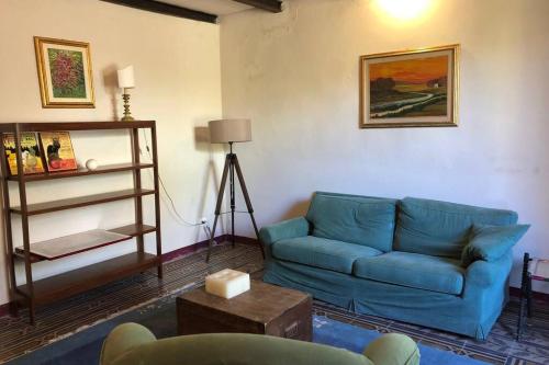 Una sala de estar con un sofá azul y una mesa. en Casina Marina, en Marina di Pisa