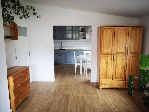 a kitchen with a wooden door and a dining room at Apartament w Dolinie Popradu 2 in Piwniczna-Zdrój