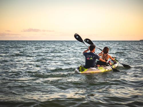 two people on a paddle board in the water at ザ・ビーチテラスホテルアオ石垣 in Ishigaki Island