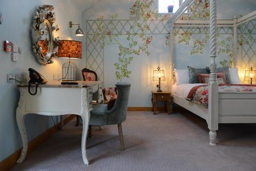 a bedroom with a bed and a desk and a white piano at Guinness Arms in Icklingham