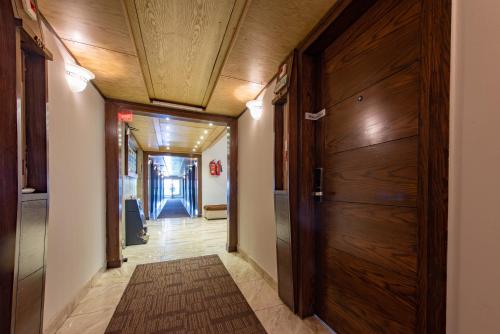 a hallway with a wooden door in a house at Envoy Continental Hotel, Islamabad in Islamabad