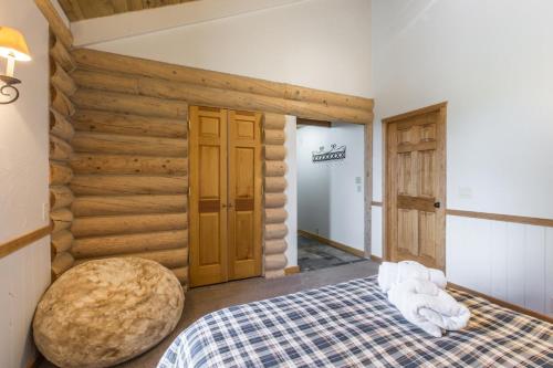 a bedroom with a bed and a wooden wall at 317 Tower Main House in Ridgway