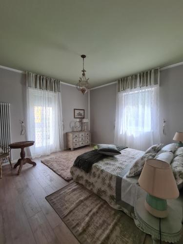 a bedroom with a bed and a table and windows at Sofia's Cottage in Sommacampagna