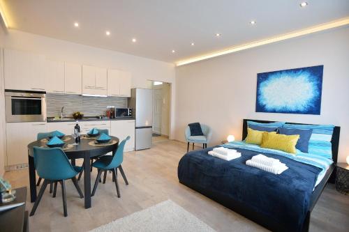 a bedroom with a bed and a table and a kitchen at NETTA APARTMAN in Eger