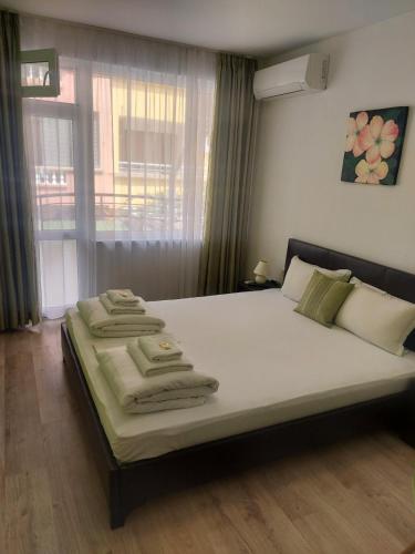 a bedroom with a large bed with towels on it at Villa Valentines in Kiten