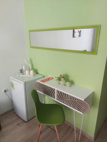 a bathroom with a green chair and a sink at Villa Valentines in Kiten