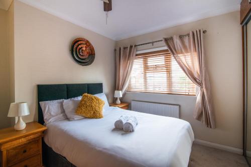 a bedroom with a bed with two shoes on it at Harmony House- Impeccable 4-Bed in Derby in Derby
