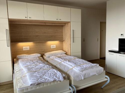 twee bedden in een kamer met witte kasten bij Haus Atlantic Whg. 402 in Cuxhaven