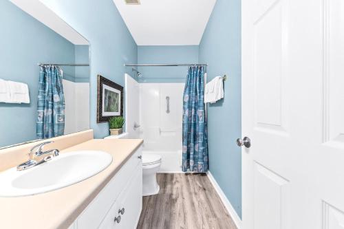 a bathroom with blue walls and a sink and a toilet at The Rookery Unit 3501 in Gulf Shores