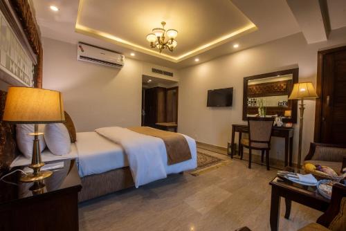 a hotel room with a bed and a living room at Envoy Continental Hotel, Islamabad in Islamabad