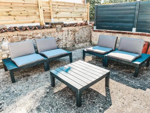 three chairs and a table and a bench at Bel appartement T3 avec terrasse in Carmaux