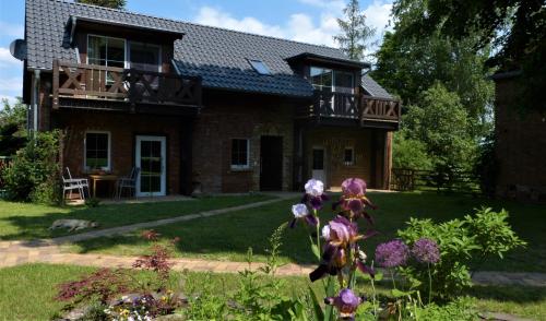 a brick house with a balcony and some flowers at Ferienwohnung im Spreewald in idyllischer Alleinlage in Werben