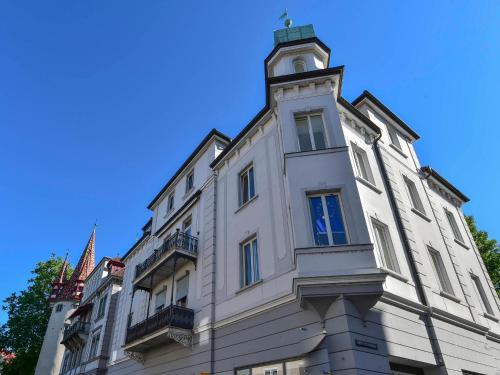 ein weißes Gebäude mit einem Uhrturm darüber in der Unterkunft The Cozy Lindau No 1 in Lindau