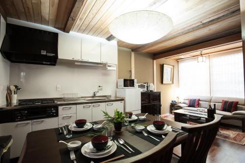 a kitchen and living room with a table and chairs at Kiyomizu Machiya Inn in Kyoto