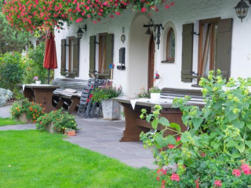 una casa con bancos y flores en el patio en Homerhof - Hofmann Johann junior, en Rottau