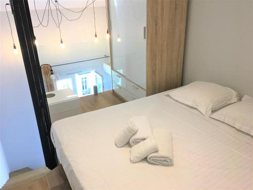 une chambre avec un lit blanc avec des serviettes dessus dans l'établissement Duplex balcon centre mer 502, à Nice