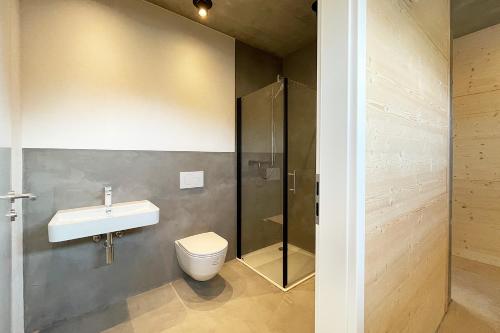 a bathroom with a sink and a toilet at Serviced Apartments - Penthouse im Herzen Königsbronns in Königsbronn