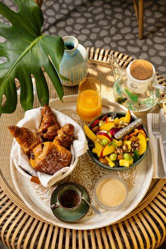 - une table avec une assiette de nourriture et un bol de fruits dans l'établissement ODSweet Duomo Milano Hotel, à Milan