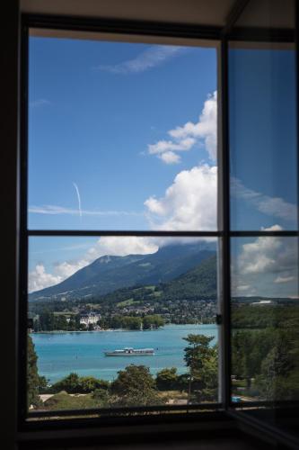 a window with a view of a body of water at Le Pélican in Annecy