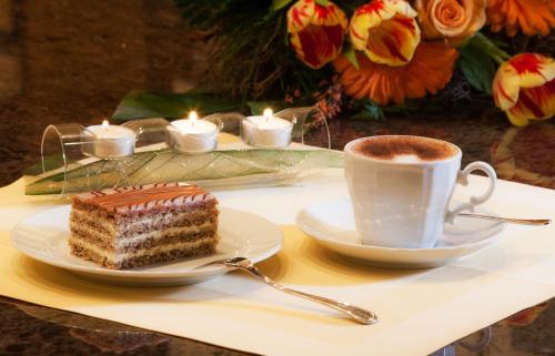 a piece of cake and a cup of coffee on a table at Landhotel Grünberg am See in Gmunden