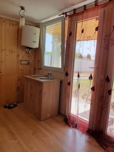 a kitchen with a sink and a large window at CAZARE LA ESPAÑOLA in Haţeg