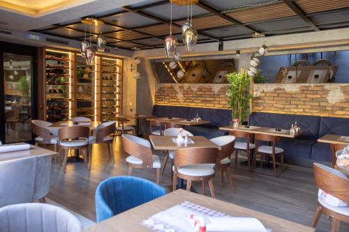 a restaurant with tables and chairs and a brick wall at Hotel Borneo in Pančevo