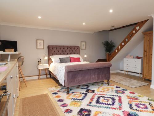 a bedroom with a large bed and a rug at Ditsys Den in Tonbridge