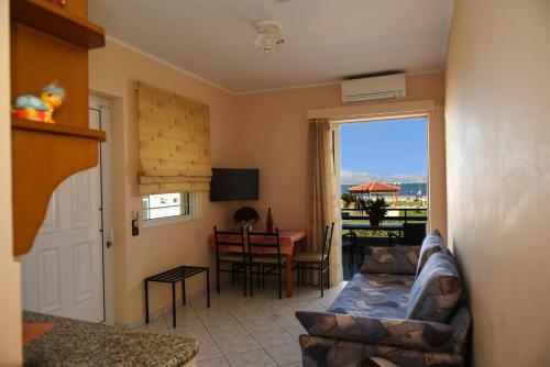 a living room with a couch and a table and a window at Akrogiali in Míloi
