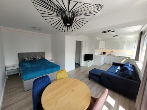 een woonkamer met een bed en een tafel bij Słoneczny Apartament przy Filharmonii, Wałach Chrobrego in Szczecin