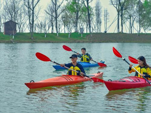 a group of people kayaking on a lake at Fairmont Yangcheng Lake in Kunshan