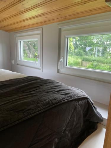 a bedroom with a bed and two windows at Herrenhaus Gut Neuruppersdorf in Timmendorfer Strand