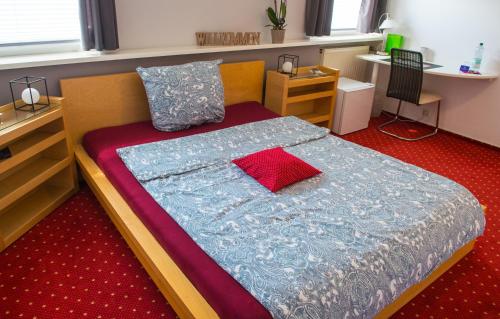 a small bedroom with a bed with a red carpet at Hotel Garni am Eckernweg in Celle