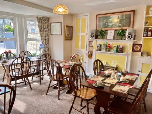 uma sala de jantar com mesa e cadeiras em APSLEY VILLA GUEST HOUSE. em Cirencester