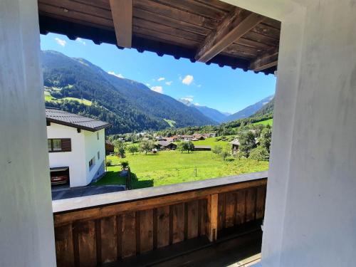 a balcony with a view of a field and mountains at Hus 172 in Gaschurn