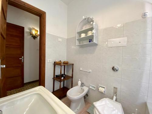 a bathroom with a tub and a toilet and a sink at Villa Tana Pacenzia in Cefalù