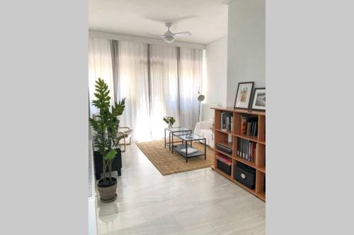 a living room with a table and a book shelf at Your cozy downtown home - Apartment in Larisa